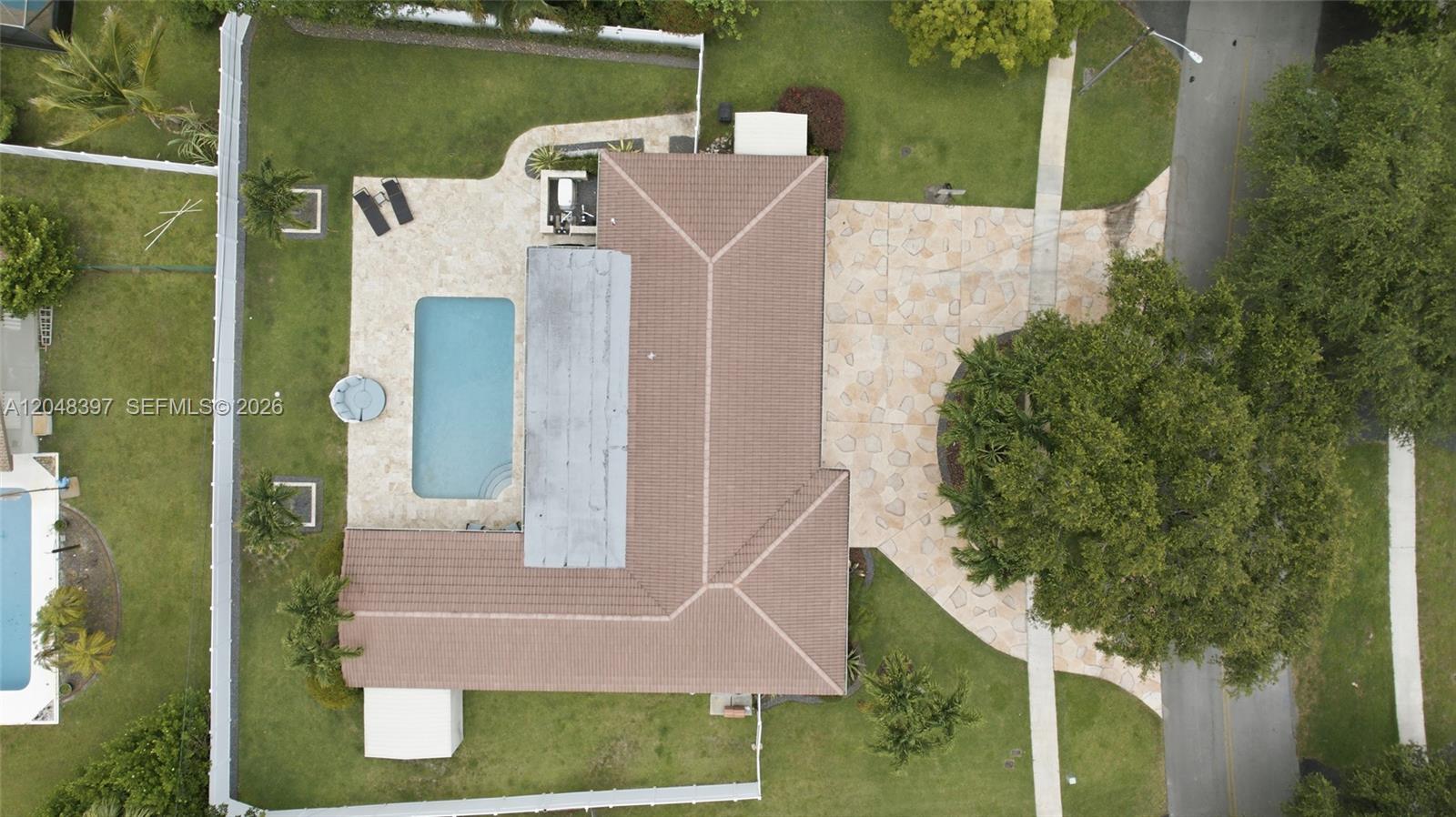 An aerial view shows a house with a tiled roof, swimming pool, and stone patio — 621 NW 74th Ave, Plantation FL 33317, PLANTATION, FL