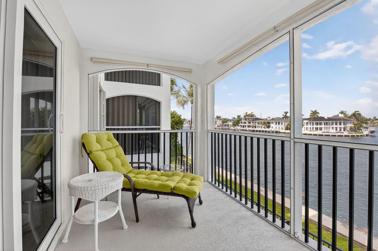 A screened-in balcony features a lounge chair, a small side table, and water views — 2871 N Ocean Boulevard # R254, Boca Raton FL 33431, BOCA RATON, FL