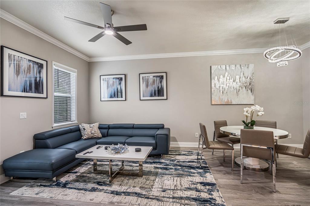 A living and dining area features a blue sectional sofa, white coffee table, and dining set — 7505 MOURNING DOVE CIRCLE UNIT 303, REUNION, FL