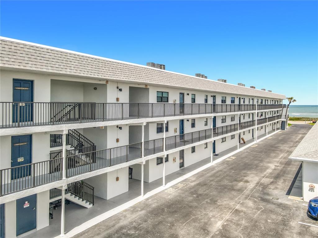 An exterior view of a multi-story apartment building with open walkways and ocean views — 2100 OCEAN SHORE BOULEVARD UNIT 2070, ORMOND BEACH, FL