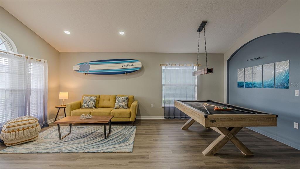 A living area features a yellow sofa, a pool table, and a surfboard wall decoration — 547 KENSINGTON DRIVE, DAVENPORT, FL