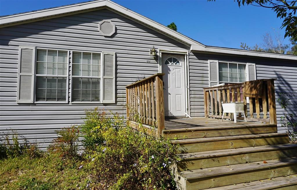 A single-story house with gray vinyl siding, a wooden deck, and front stairs — 5012 S ORWELL POINT, HOMOSASSA, FL