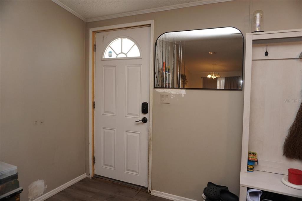An entryway features a white front door, a wall-mounted mirror, and a white storage unit — 5012 S ORWELL POINT, HOMOSASSA, FL