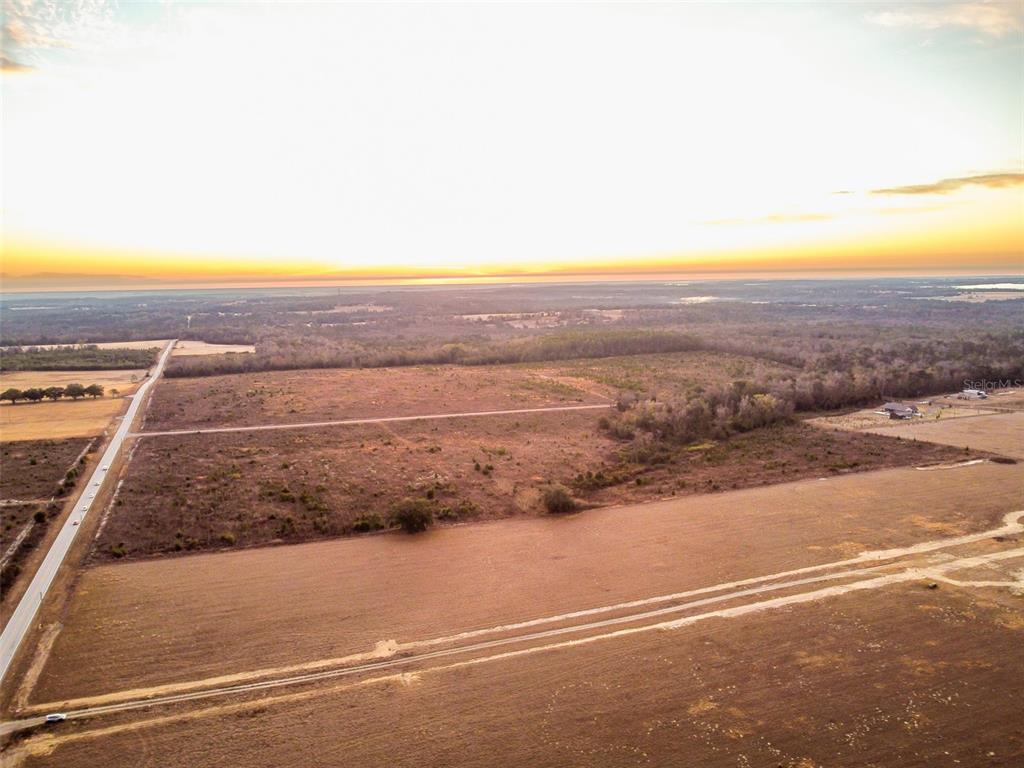 An aerial view shows a large, flat, undeveloped plot of land with a dirt road — 4178 ROYAL SKY (LOT 8 ) COURT, BROOKSVILLE, FL