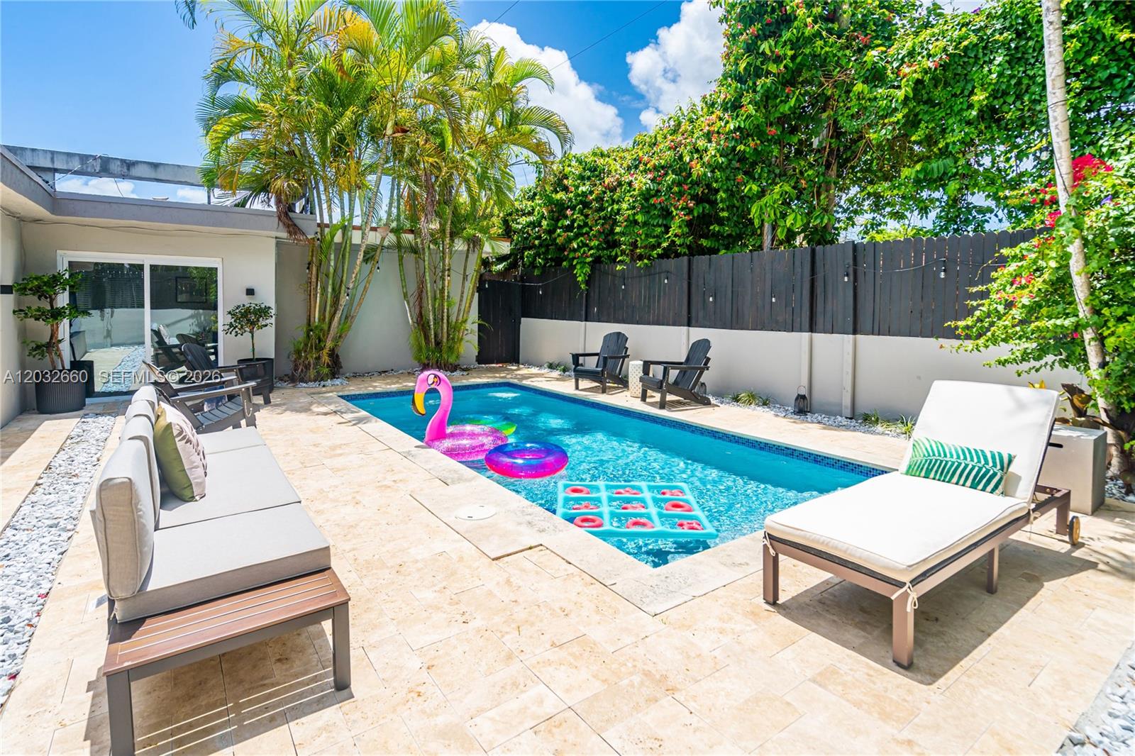 A backyard patio features a rectangular swimming pool, lounge chairs, and tropical landscaping — 520 SW 22 rd, Miami FL 33129, MIAMI, FL