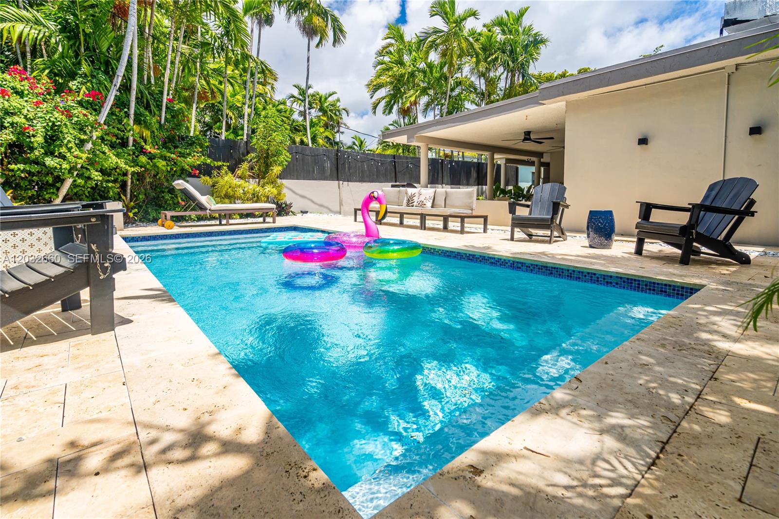 A backyard swimming pool features a patio, lounge chairs, and inflatable pool floats — 520 SW 22 rd, Miami FL 33129, MIAMI, FL