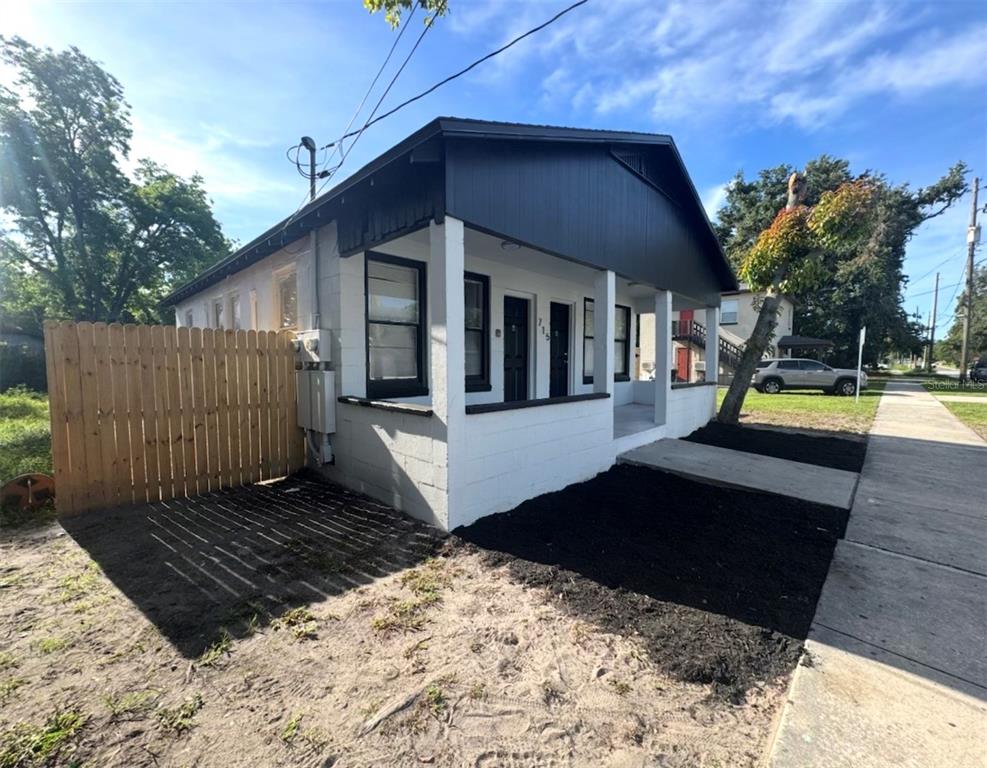 A white, single-story house with a black-painted gable roof and a small front porch — 715 JERNIGAN AVENUE, ORLANDO, FL