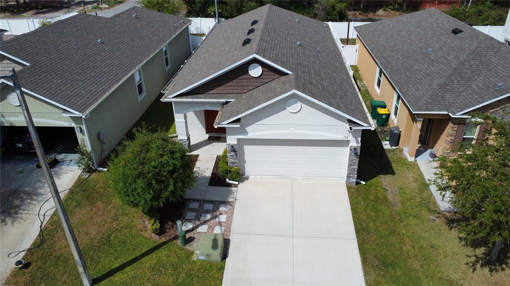 An aerial view shows a single-story suburban house with a two-car garage and driveway — 118 HURST CT, DELAND, FL