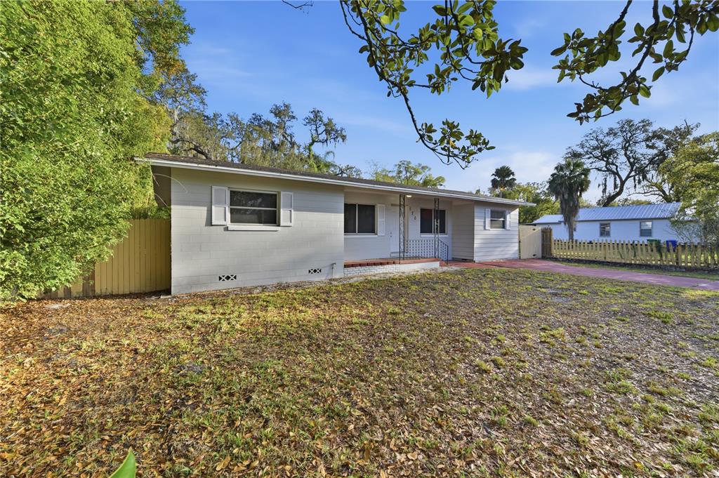 A single-story gray concrete block house with a front porch and a large yard — 170 W CRYSTAL LAKE AVENUE, LAKE MARY, FL