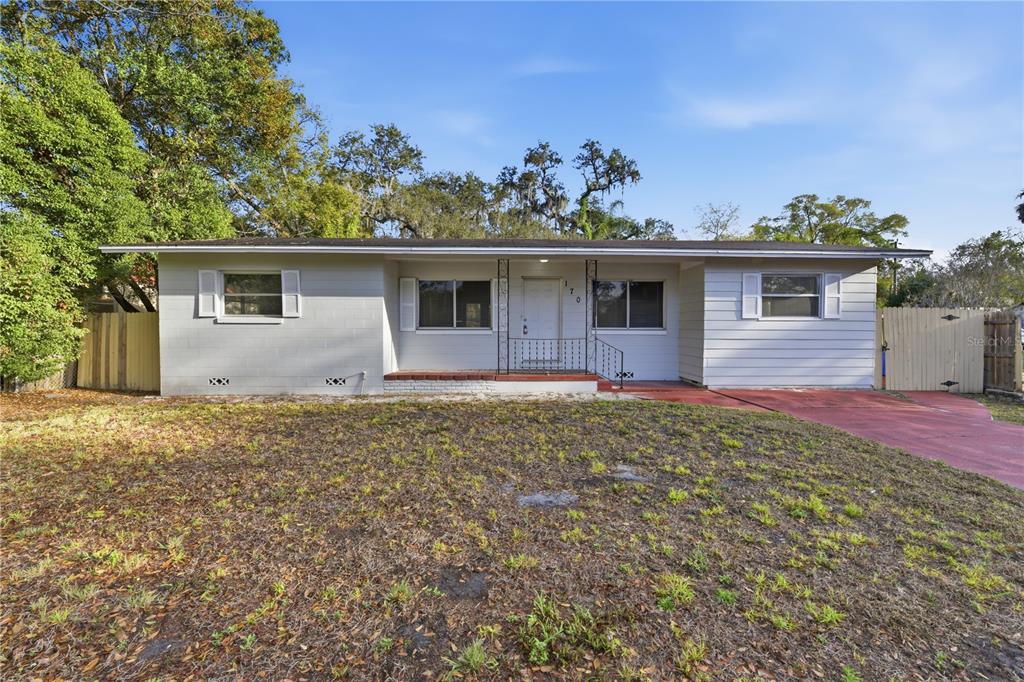 A single-story house with a light gray exterior, a red driveway, and a front porch — 170 W CRYSTAL LAKE AVENUE, LAKE MARY, FL
