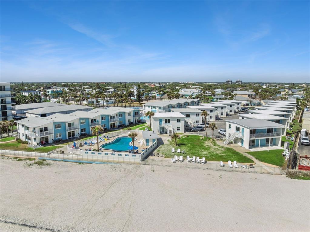 An aerial view of a beachfront resort complex featuring multiple buildings and a swimming pool — 513 N ATLANTIC AVENUE UNIT 33, NEW SMYRNA BEACH, FL