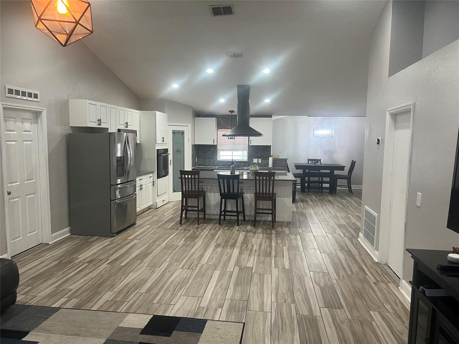 A kitchen with white cabinets, a center island, and wood-look tile flooring — 5091 Plymouth Turtle Circle, FL 34772, FL