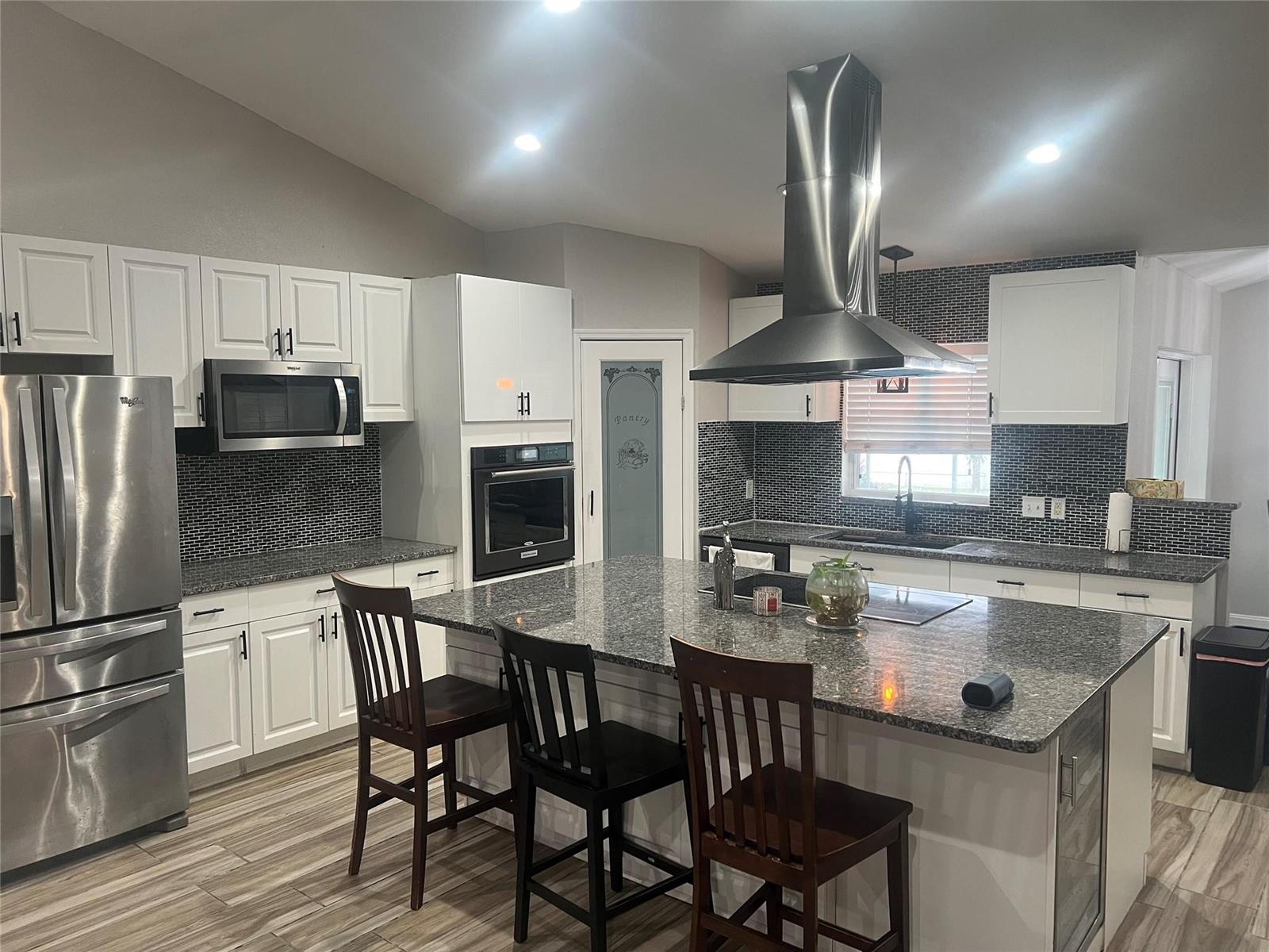 A kitchen features white cabinets, granite countertops, a large island, and stainless steel appliances — 5091 Plymouth Turtle Circle, FL 34772, FL