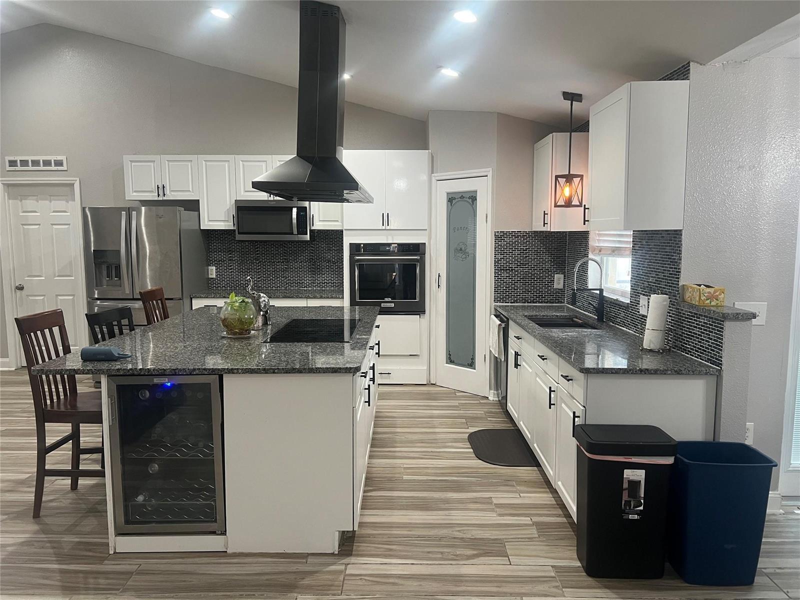 A kitchen features white cabinets, granite countertops, a large island, and black tile backsplashes — 5091 Plymouth Turtle Circle, FL 34772, FL