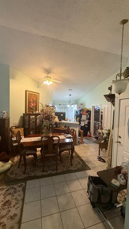 A dining area with a wooden table and chairs sits beneath a ceiling fan — 4100 NATCHEZ TRACE DRIVE, ST CLOUD, FL