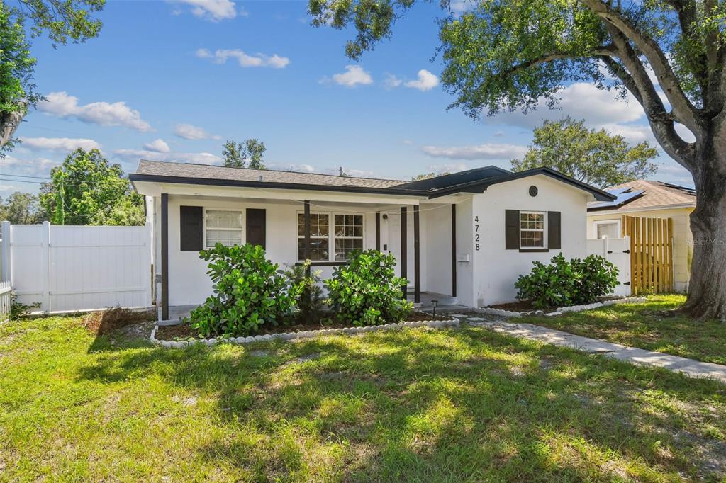 A single-story white house with black shutters and a covered front porch — 4728 9TH AVENUE N, ST PETERSBURG, FL