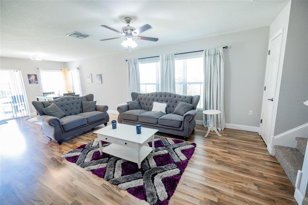 A living room features two gray tufted sofas, a white coffee table, and a purple rug — 4514 LIMERICK DRIVE, TAMPA, FL