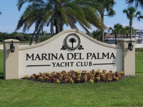 A beige monument sign for Marina Del Palma Yacht Club stands in a grassy lawn — 87 DEL PALMA DRIVE, PALM COAST, FL