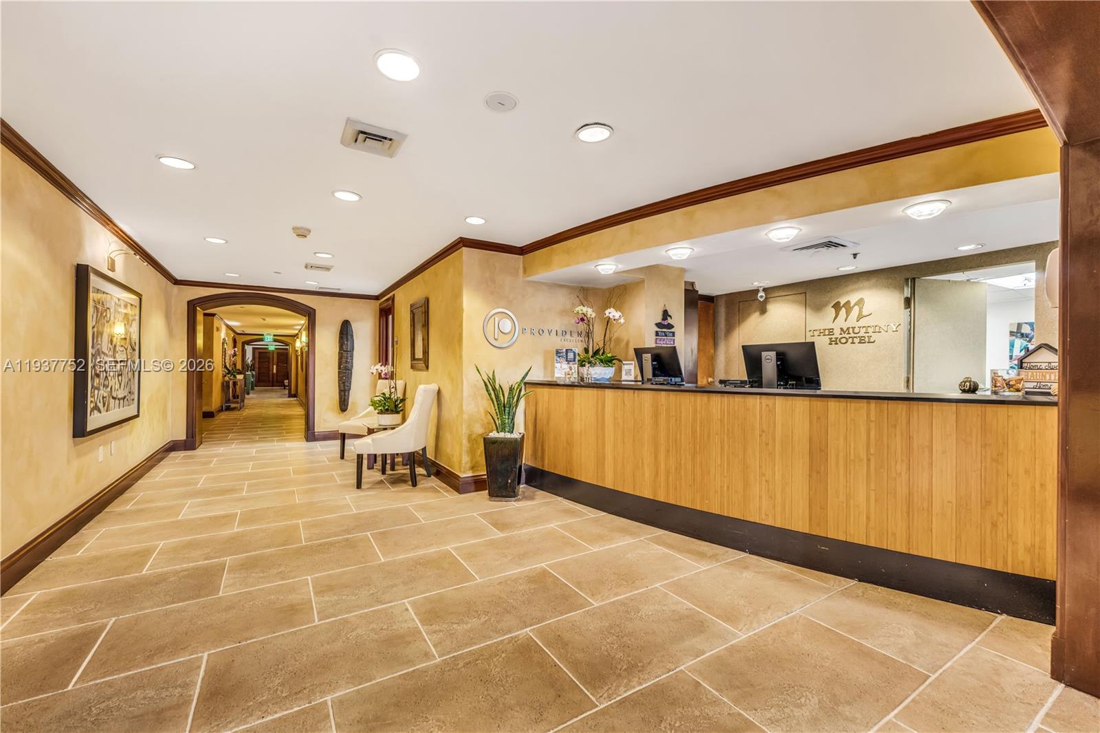 The hotel lobby features a wooden reception desk, tile flooring, and a hallway entrance — 2951 S Bayshore Dr # 717, Miami FL 33133, MIAMI, FL