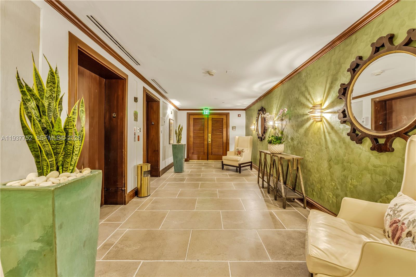 A hallway features tile flooring, green textured walls, wooden doors, and decorative mirrors — 2951 S Bayshore Dr # 717, Miami FL 33133, MIAMI, FL