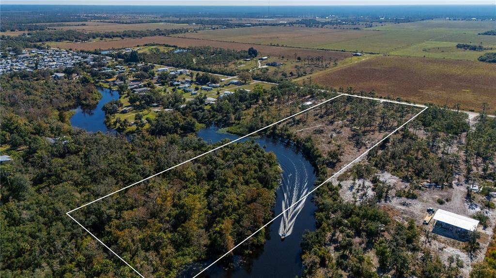 An aerial view shows a rectangular plot of land bordering a winding river — 36051 WASHINGTON LOOP ROAD, PUNTA GORDA, FL