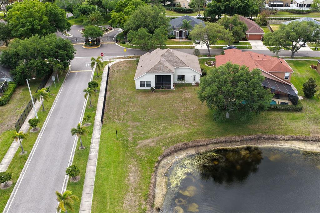 An aerial view shows a house with a screened lanai next to a pond — 9103 PINEBREEZE DRIVE, RIVERVIEW, FL