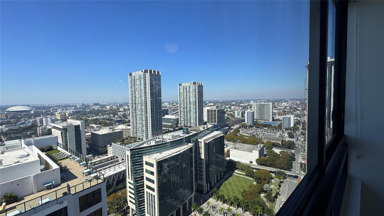 A high-angle view of a city skyline featuring modern skyscrapers and a domed stadium — 225 N Miami Avenue # 3604, Miami FL 33128, MIAMI, FL