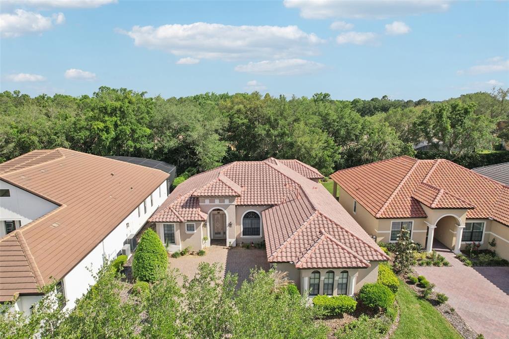 An aerial view shows three suburban houses with tiled roofs and paved driveways — 26345 SAN GABRIEL, HOWEY IN THE HILLS, FL