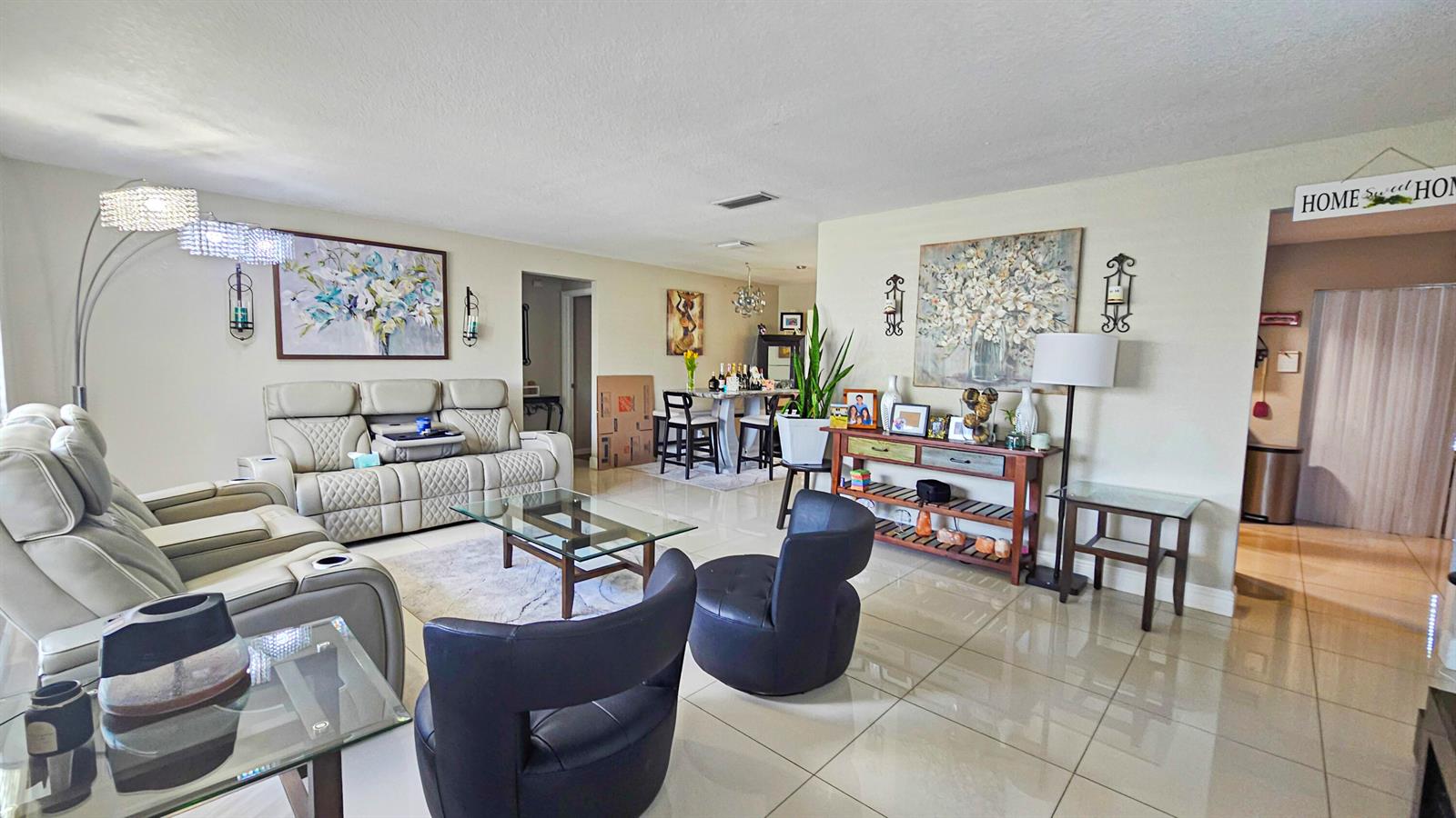 An empty room with light-colored tile flooring, beige walls, a large window, and a door — 7180 NW 10th Court, Margate FL 33063, MARGATE, FL