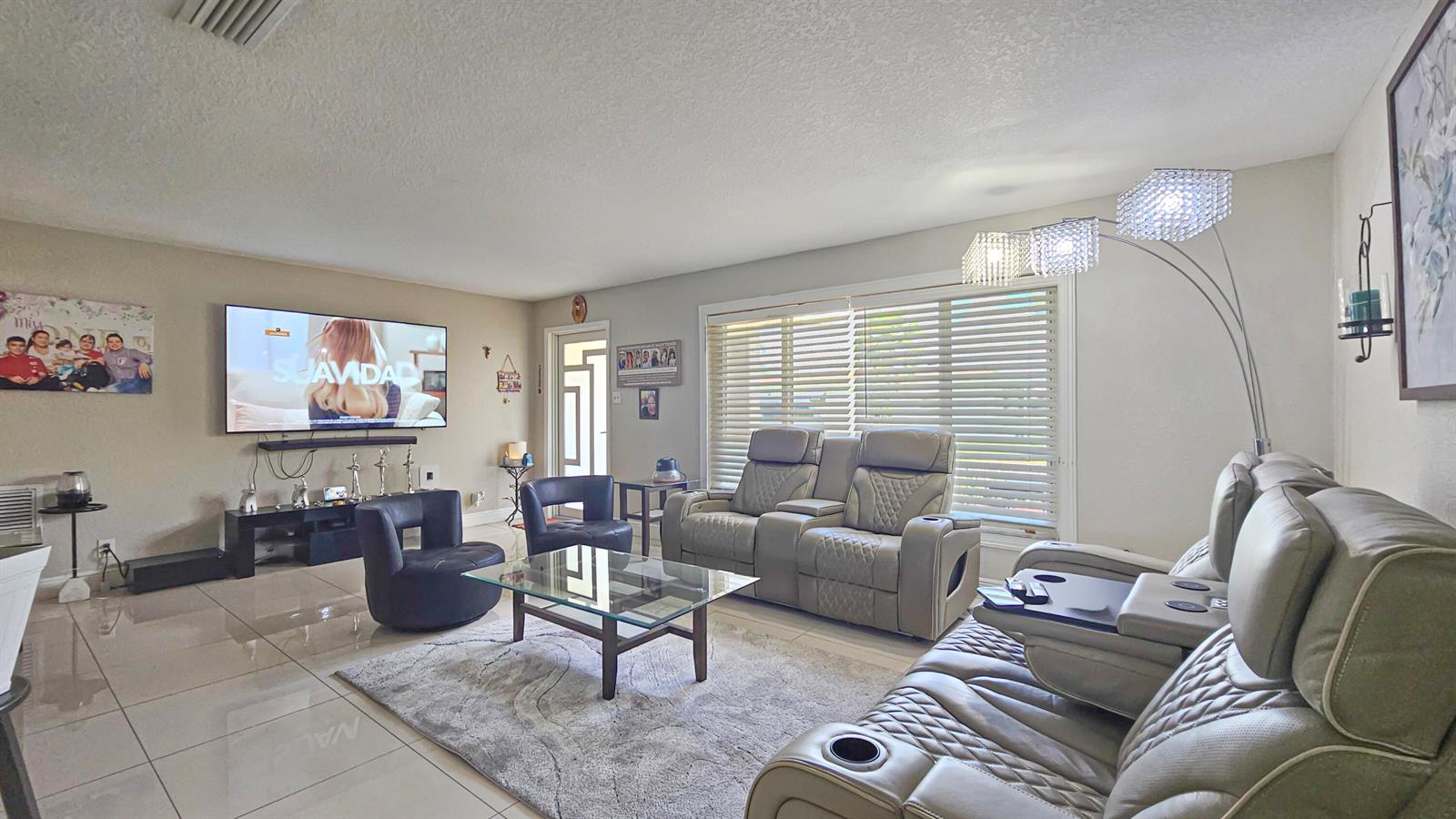 An empty room with light beige walls, white baseboards, and glossy, light-colored tile flooring — 7180 NW 10th Court, Margate FL 33063, MARGATE, FL