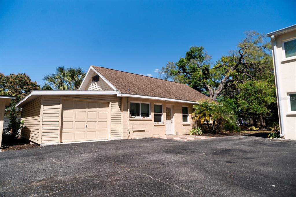 A tan, single-story house with a garage and asphalt driveway under a clear blue sky — 400 20TH STREET E UNIT 1-6, BRADENTON, FL