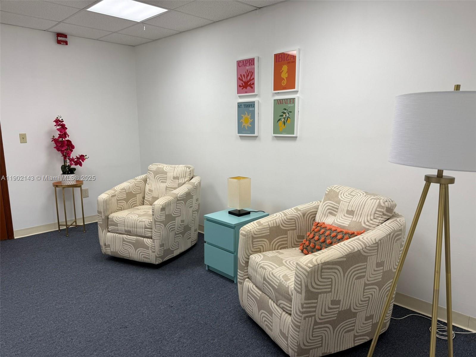 A waiting room features two patterned armchairs, a blue side table, and four framed prints — 220 Miracle Mile # B219, Coral Gables FL 33134, CORAL GABLES, FL