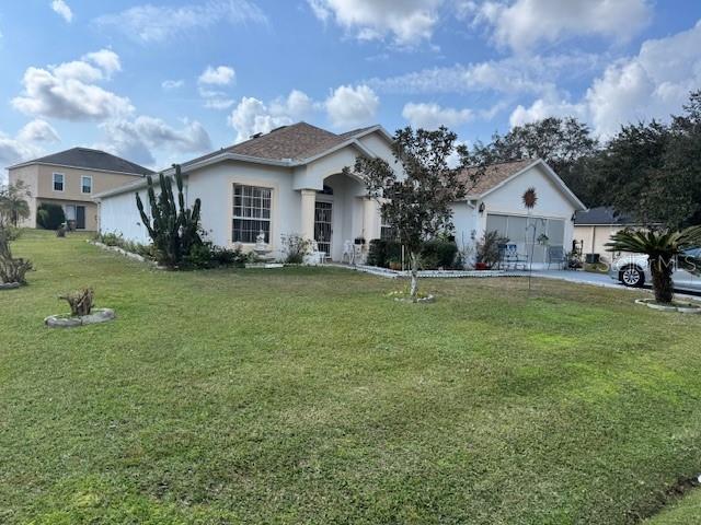 A single-story house with a light-colored exterior and a large front lawn — 813 HALIFAX DRIVE, KISSIMMEE, FL