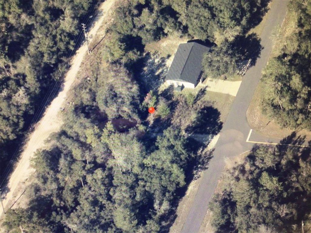 An aerial view shows a house with a dark roof surrounded by dense trees — 0 SW 35 COURT ROAD, OCALA, FL