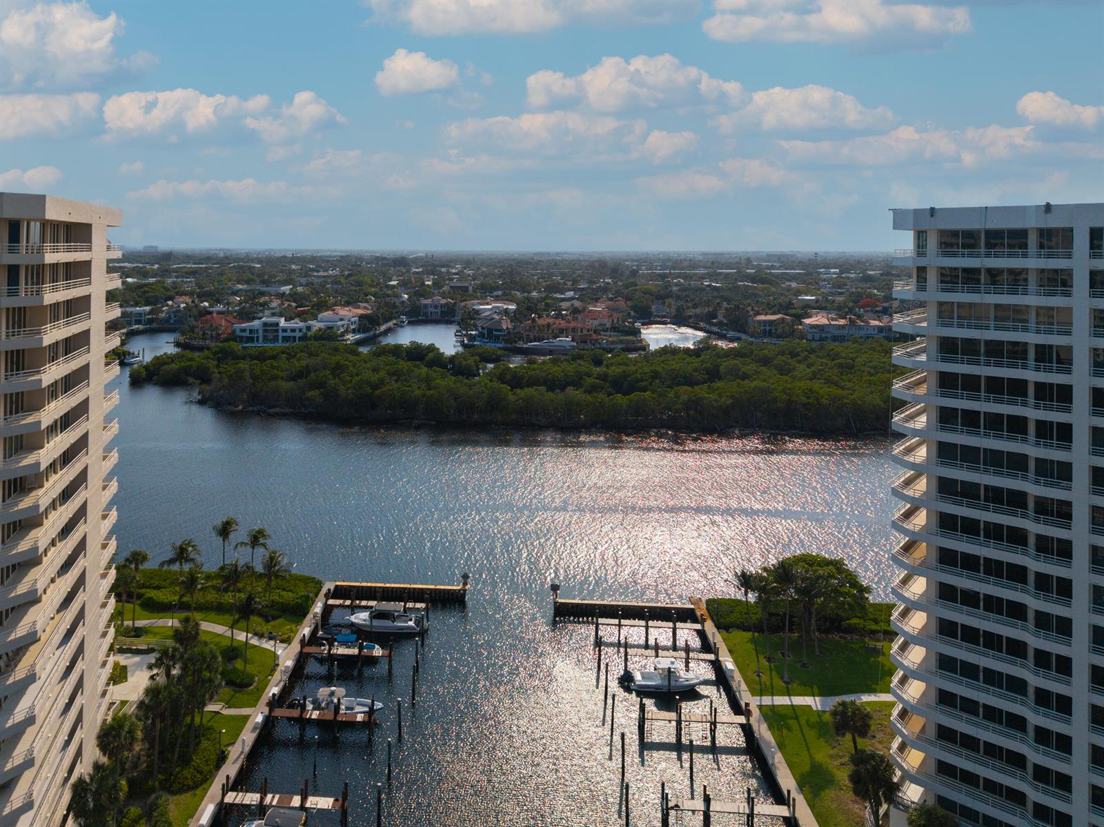 An aerial view shows a marina between two tall residential buildings overlooking a waterway — 4201 N Ocean Boulevard # 508, Boca Raton FL 33431, BOCA RATON, FL