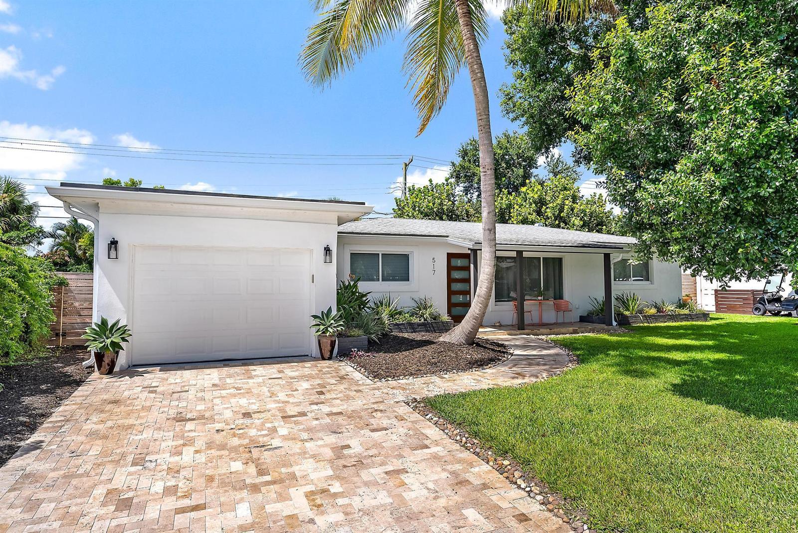 A single-story white house features a paver driveway, a garage, and a palm tree — 517 Gulf Road, North Palm Beach FL 33408, NORTH PALM BEACH, FL