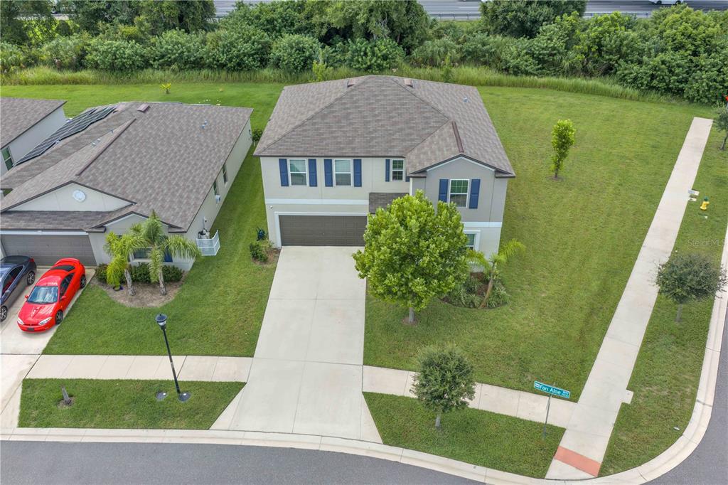 An aerial view shows a two-story suburban house with a driveway and a corner lot — 1911 FAN ALOE WAY, RUSKIN, FL