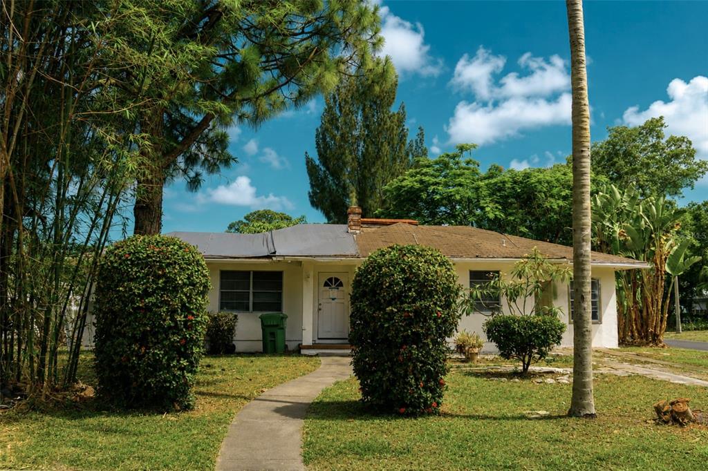A single-story house with a white exterior, a two-toned roof, and two large manicured bushes — 1302 28TH STREET W, BRADENTON, FL