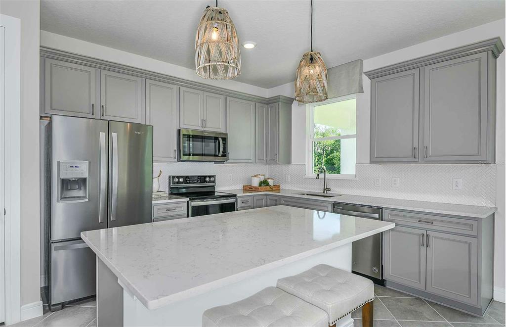 A kitchen with gray cabinets, white countertops, a center island, and two woven pendant lights — 11119 SYCAMORE GLEN LOOP, THONOTOSASSA, FL