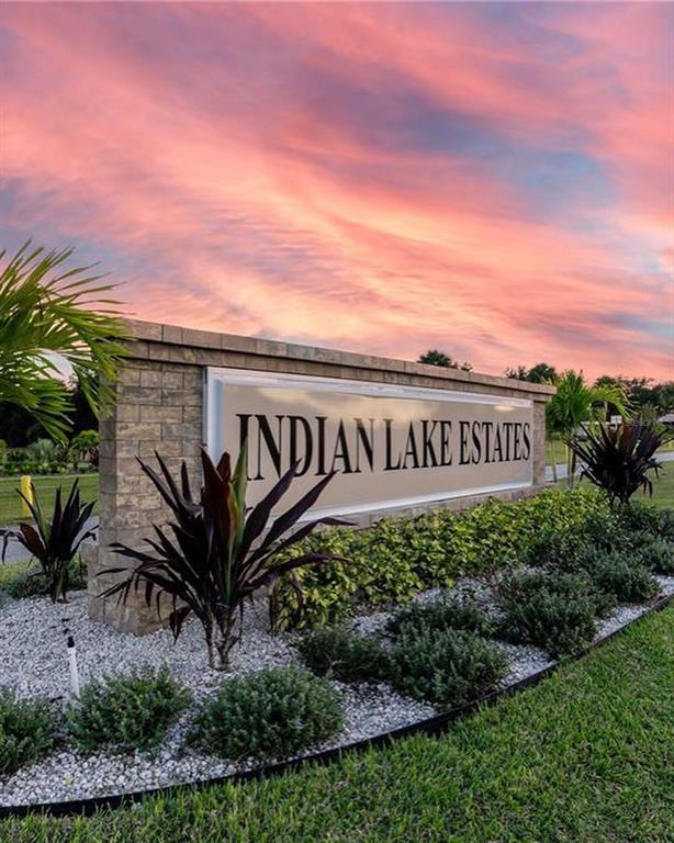 A stone monument sign for Indian Lake Estates stands in a landscaped garden at sunset — 1020 ALTHEA DRIVE, INDIAN LAKE ESTATES, FL