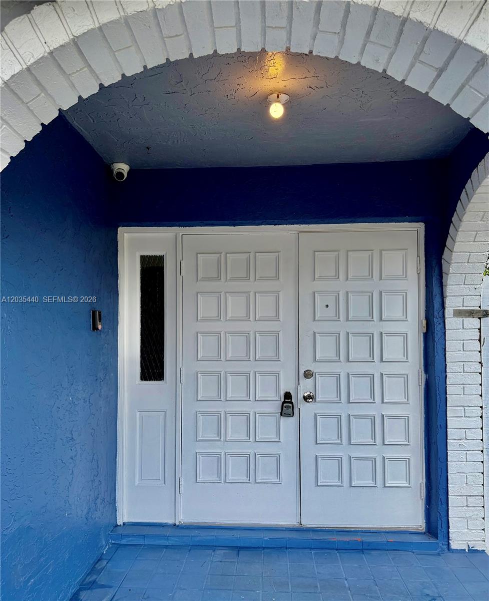 A blue-painted entryway features a white double door with a sidelight under a brick arch — 6182 SW 4th St, Margate FL 33068, MARGATE, FL