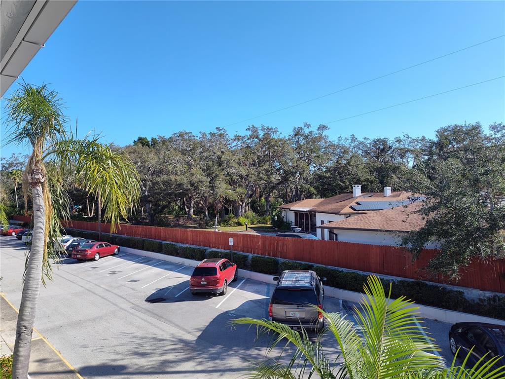 An elevated view shows a parking lot with several cars next to a wooden fence — 4060 55TH STREET N UNIT 1209, KENNETH CITY, FL