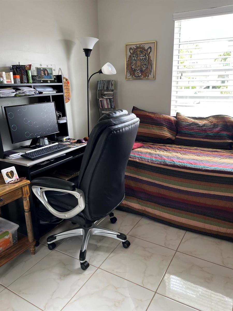 A home office featuring a desk, black leather chair, daybed, and a tiger wall art piece — 358 Burgundy H, Delray Beach FL 33484, DELRAY BEACH, FL