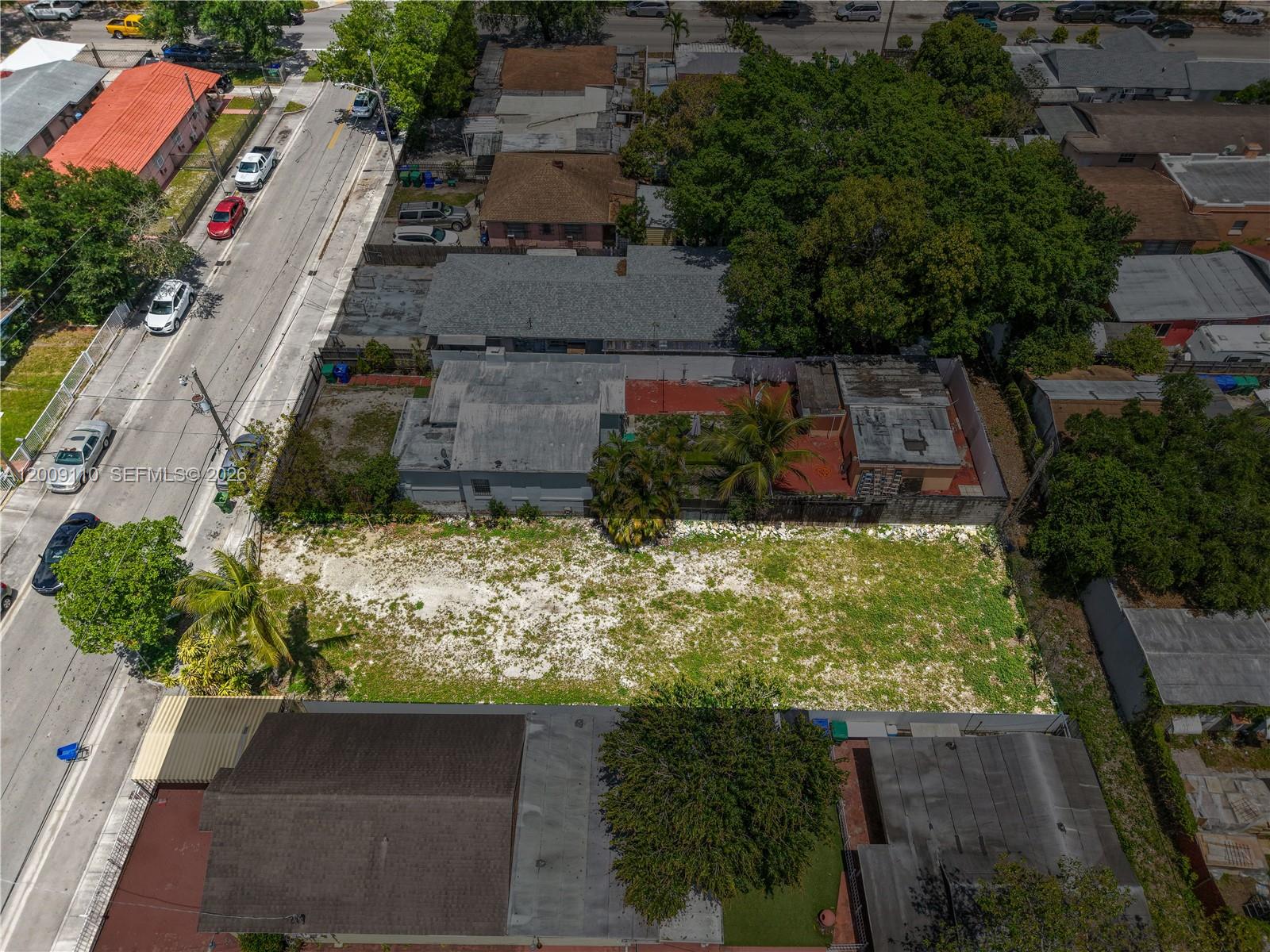 An aerial view shows a vacant lot situated between two residential properties along a street — 2709 NW 24th Ave, Miami FL 33142, MIAMI, FL