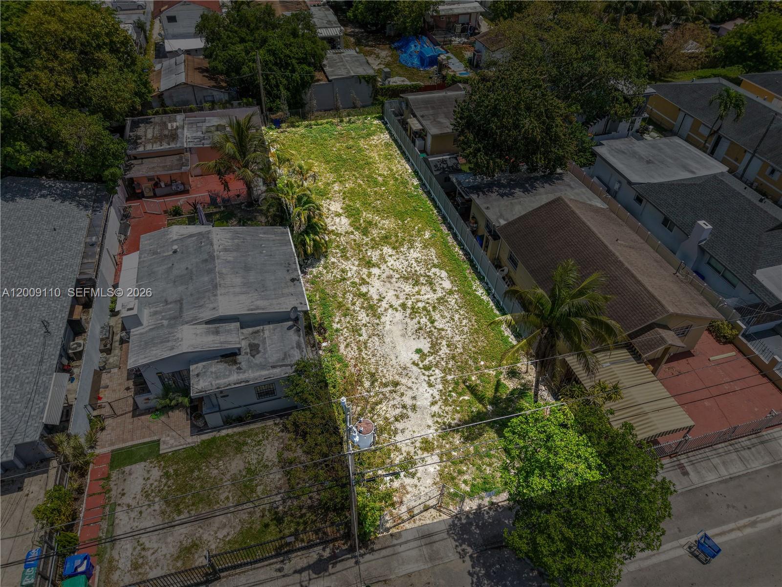 An aerial view shows a vacant, sandy residential lot situated between two existing houses — 2709 NW 24th Ave, Miami FL 33142, MIAMI, FL