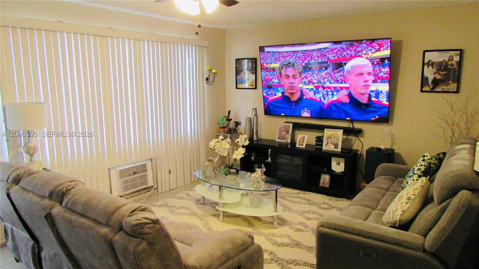 A living room features a large wall-mounted television, gray sofas, and a glass coffee table — 389 Tilford R # 389, Deerfield Beach FL 33442, DEERFIELD BEACH, FL