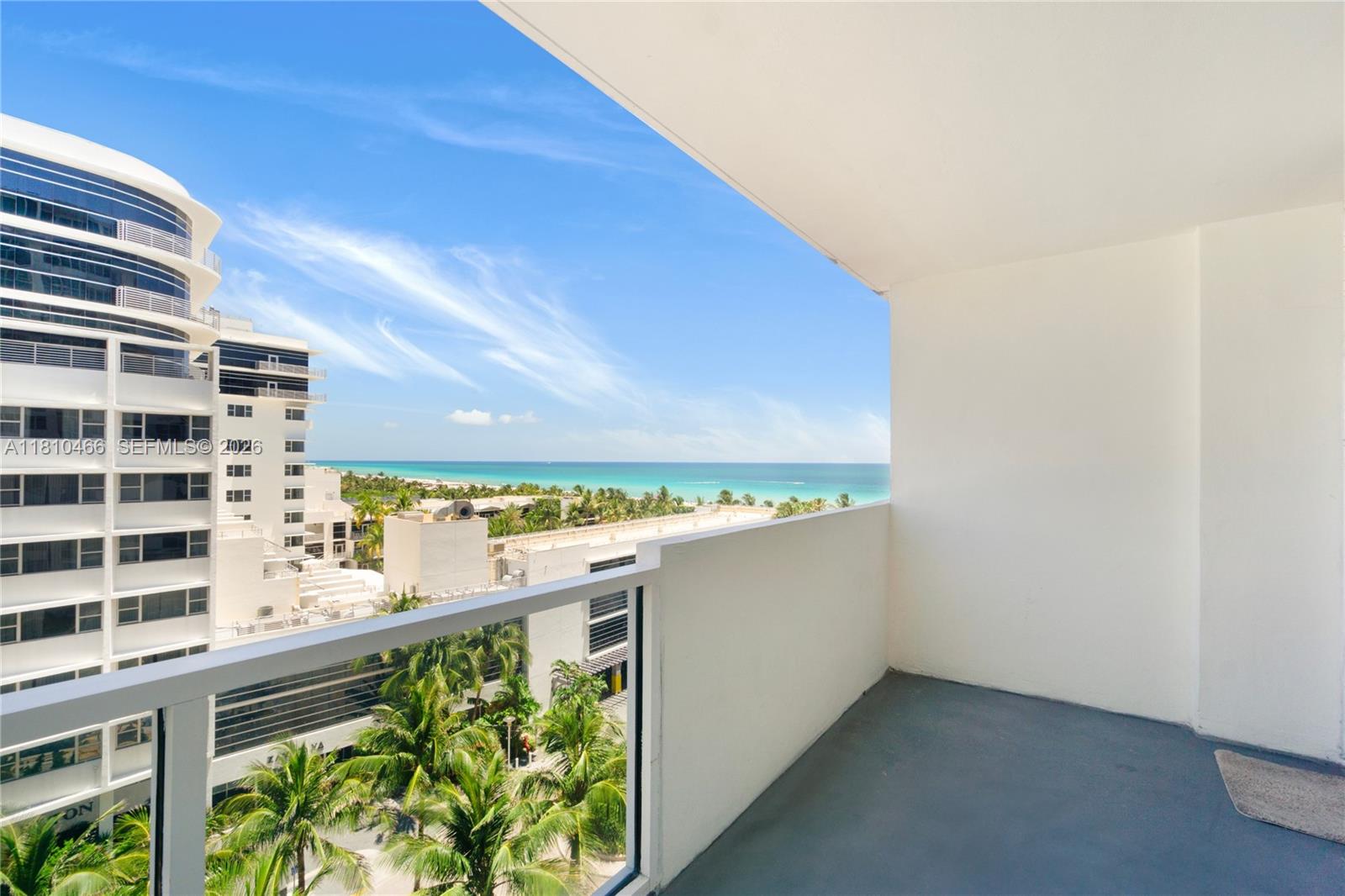 A balcony with a glass railing overlooks a coastal city and the ocean — 100 Lincoln Rd # 827, Miami Beach FL 33139, MIAMI BEACH, FL
