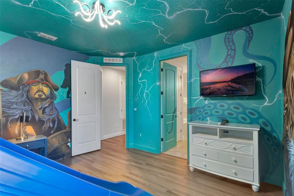 A themed bedroom features a pirate mural, a slide, and a television mounted on the wall — 7643 WILMINGTON LOOP, KISSIMMEE, FL