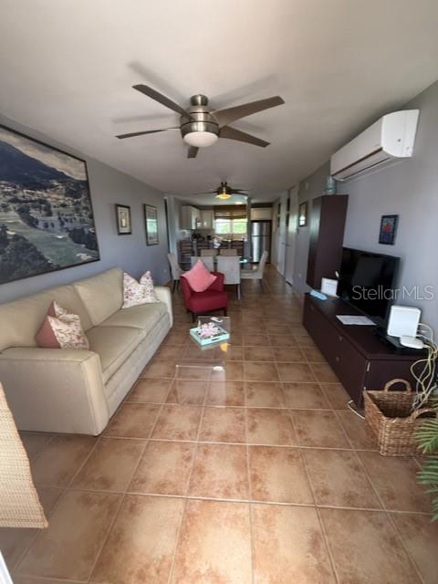 A living room features a beige sofa, a red armchair, tile flooring, and a ceiling fan — Cond. Bosque del Mar EDIFICIO A UNIT H-302, RIO GRANDE, PR