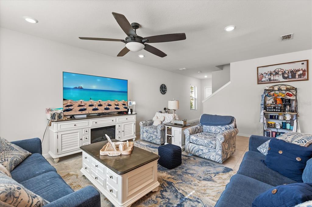 A living room features blue patterned furniture, a white media console, and a ceiling fan — 2224 CANOPY TERRACE BOULEVARD, DELAND, FL